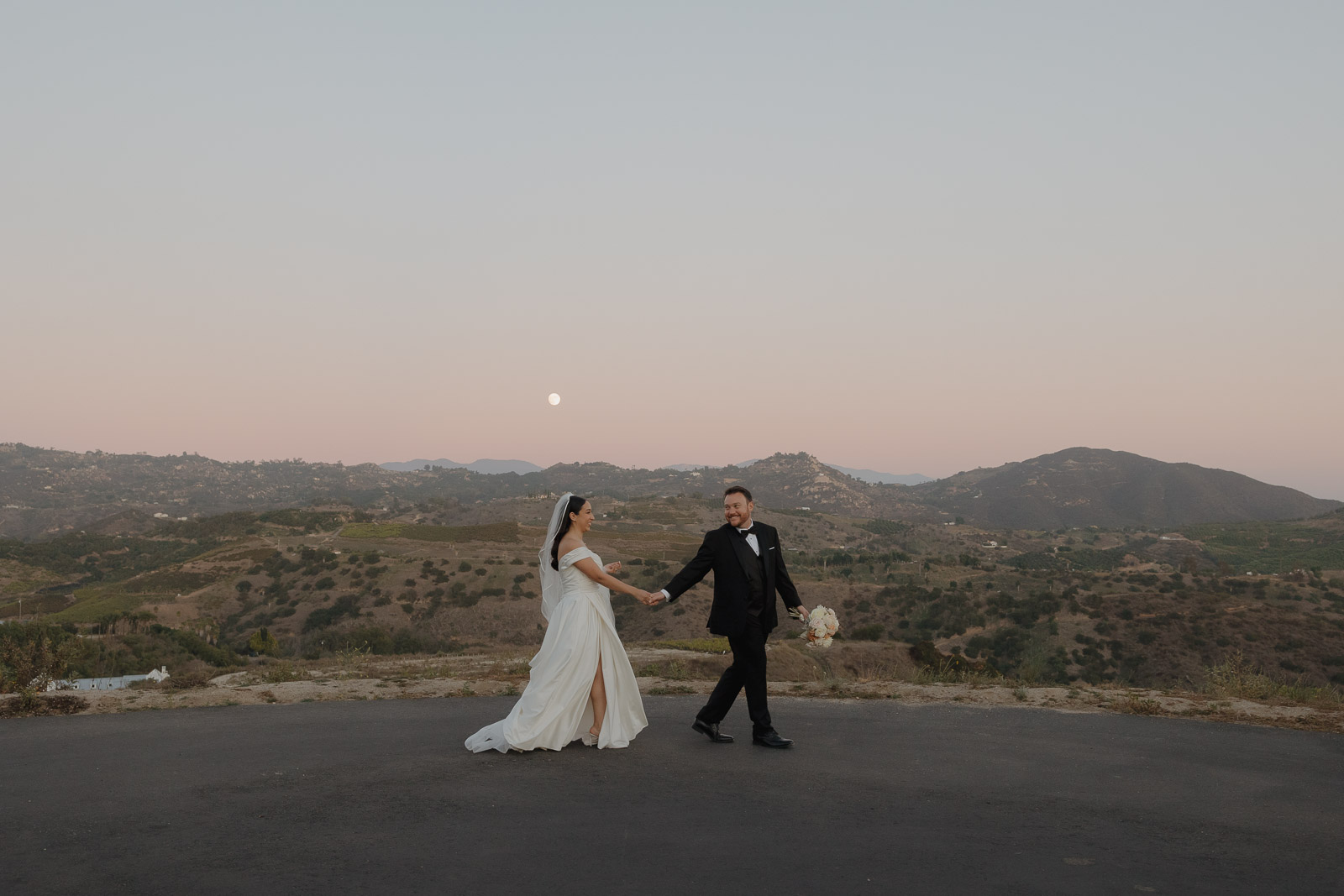bride and groom walk at blue hour over valley view at Tivoli Italian Villa
